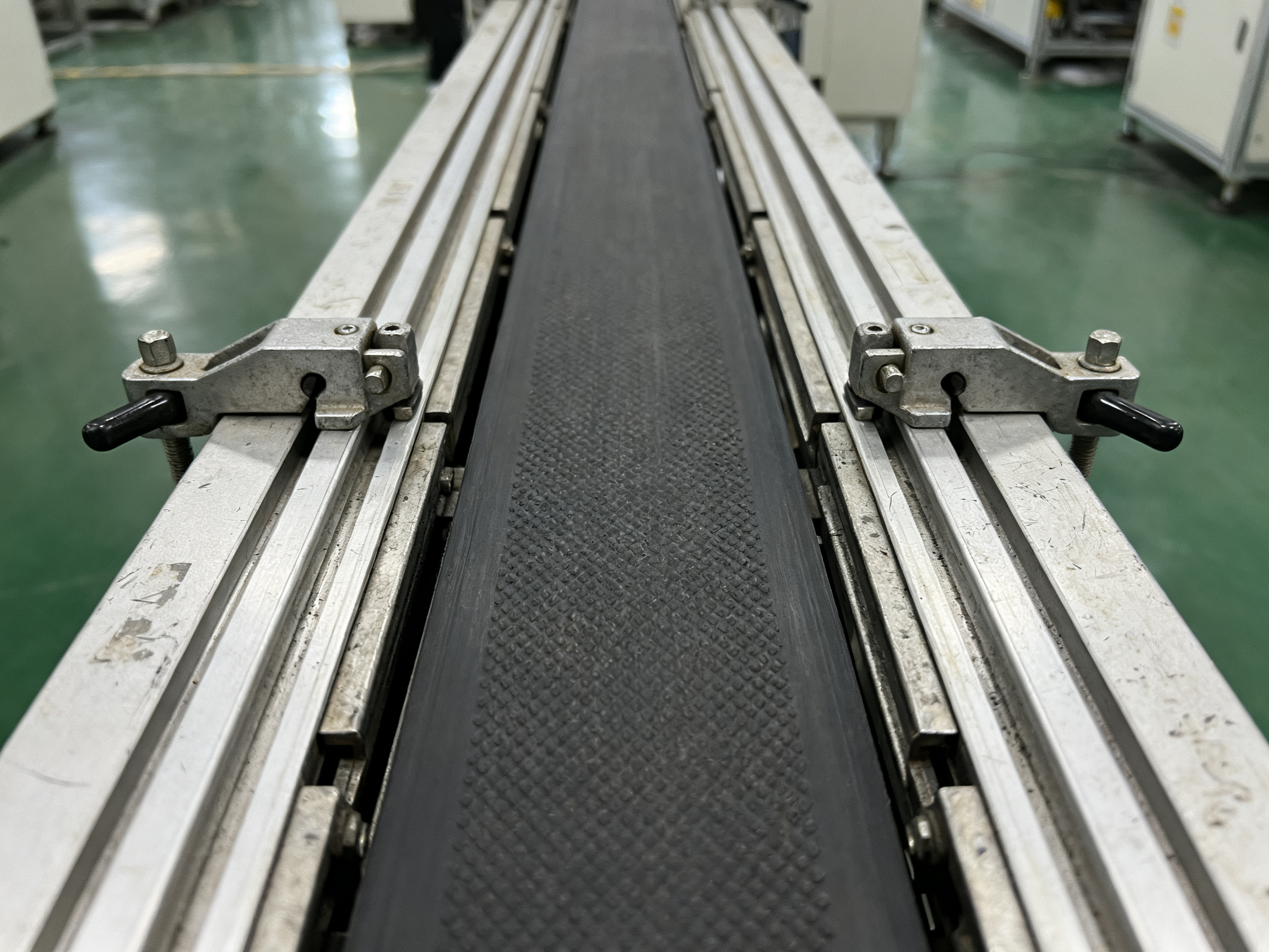 Close up detail of smt conveyor rail width adjustment mechanism showing parallel alignment.