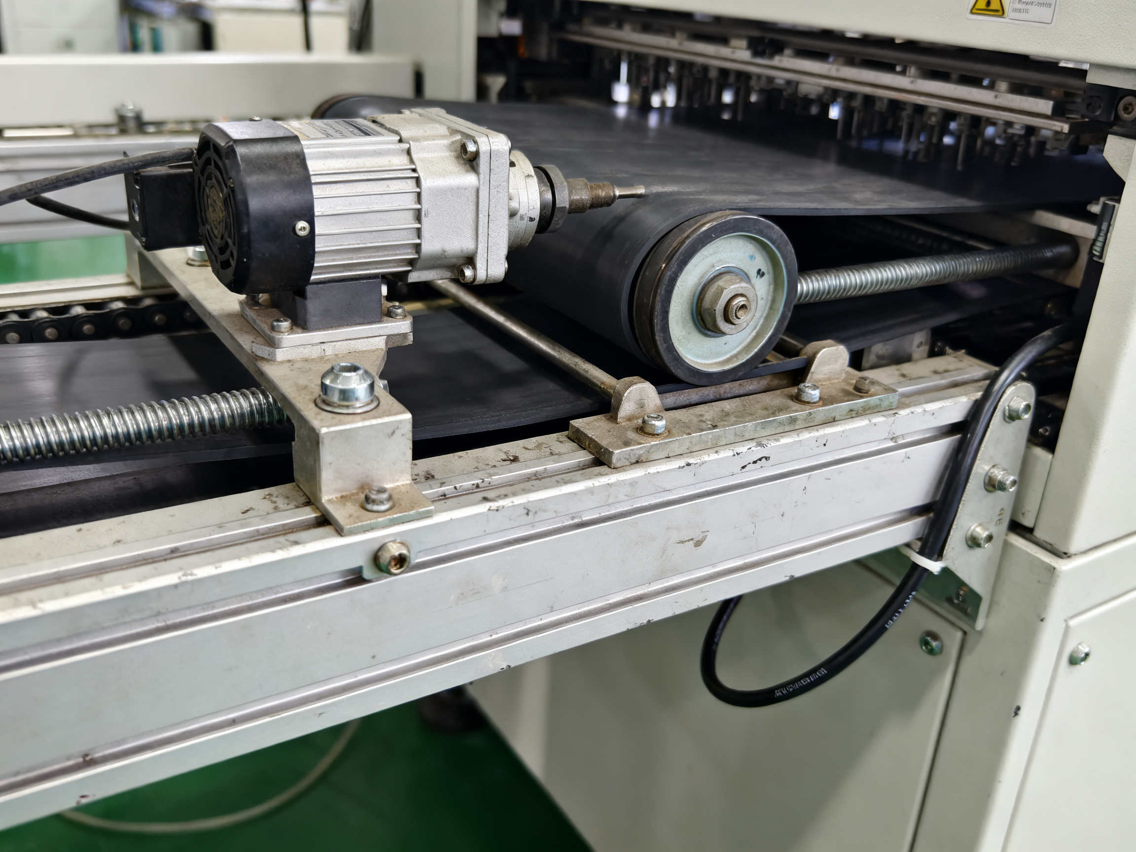 PCB Handling Conveyor Guide: How It Works, Types, and How to Choose for SMT Lines1 - S&M Co.Ltd Close documentary detail of conveyor belt tensioning and alignment mechanism on industrial equipment.