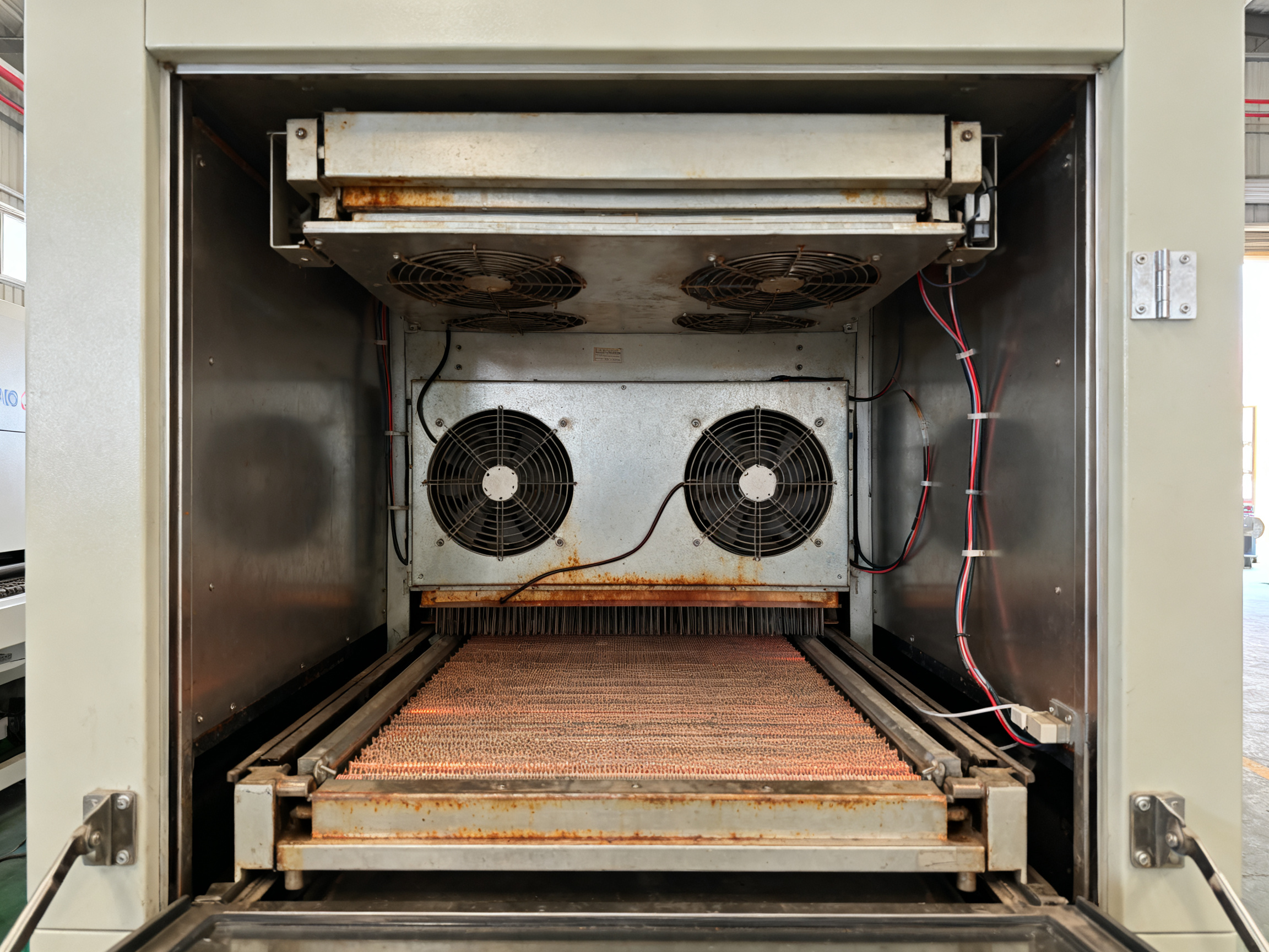 Reflow Oven Price Guide: Global Trends, Brand Breakdown, and Regional Comparisons (2026)1 - S&M Co.Ltd Close up detail of an SMT reflow oven heating zone interior with door open showing components and thermal elements inside the chamber.