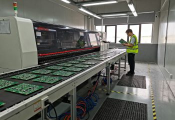 1790292082-smt-production-line-with-reflow-oven-conveyor-belt-carrying-populated-pcbs-overh-1790292080228